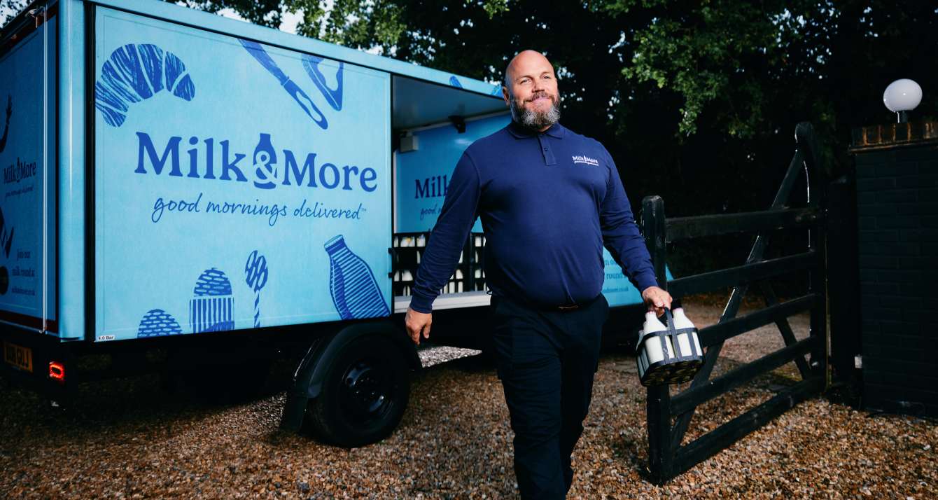 Milkman with glass bottles of milk